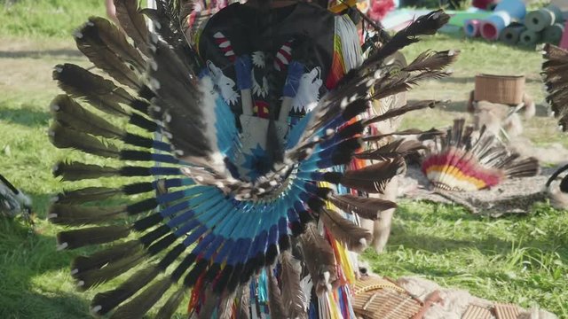 View of part of Peruvian dress made of feathers on true Peruvian playing flute and dancing outdoors
