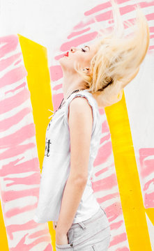 Trendy and beautiful female in front of yellow and pink wall with animal print on it.