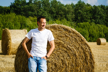 Naklejka na ściany i meble Happy smiling caucasian thirty years old farmer standing proud in front of his wheat fields