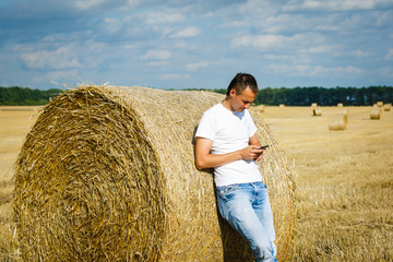Naklejka na ściany i meble Man, male in the rural wheat agriculture field. Countryside nature landscape. Farmer in the farm. Harvest crop.