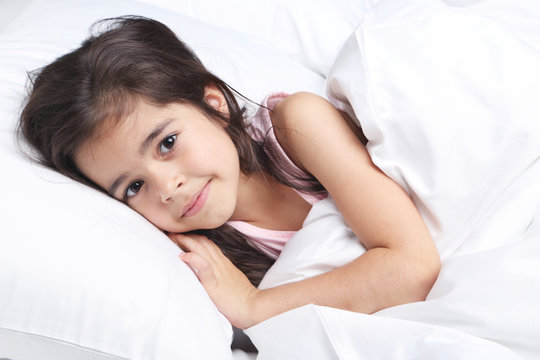 Beautiful little girl sleeping in white bed