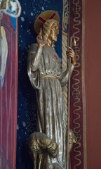  gold sculpture of a bishop standing in the nave of a colorful oriental temple