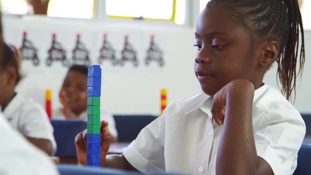 Schoolgirl counting with blocks at an elementary school