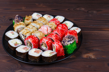 Colorful set of japanese sushi maki rolls with salmon, tuna and avocado served on round plate