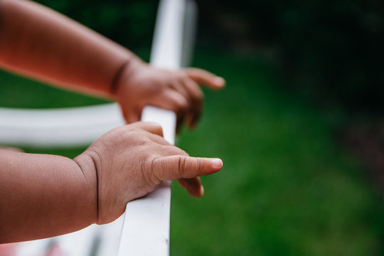 Hands of a todler on a white bench