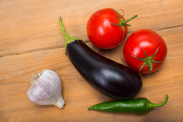 Vegetables on vintage wood background - summer harvest, soup ingredients. Rural still life from above. Tomato, eggplant, garlic, pepper