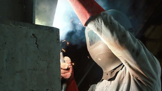 Welder welds the parts of the structure. Manufacture of reinforced concrete structures. Welding is an integral part of the technological process. 