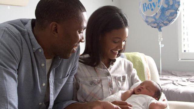 Parents Home from Hospital With Newborn Baby In Nursery