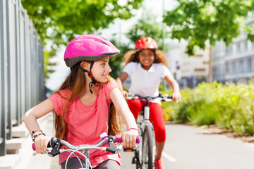 Happy girls riding bikes during summer vacation