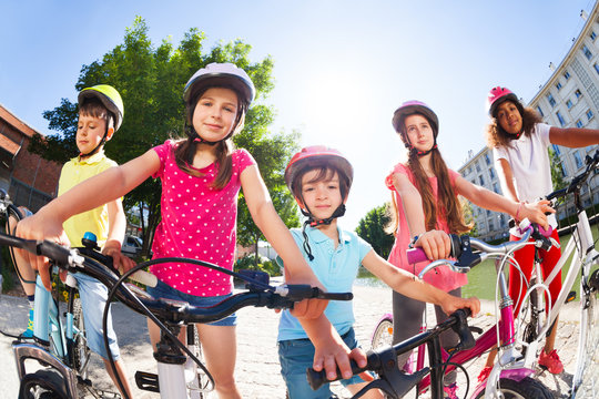 Children standing together with bicycles in summer