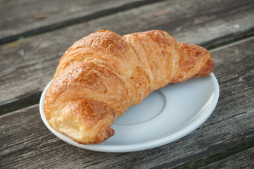croissant dans une assiette sur une table en bois