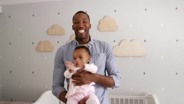 Father Holding Baby Daughter In Nursery Shot In Slow Motion