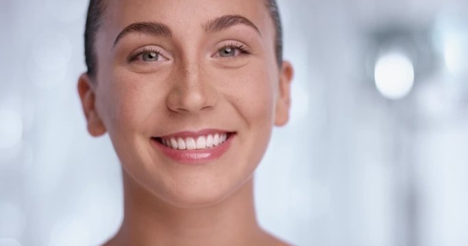 Beautiful young woman turning her head to camera and giving a radiant smile