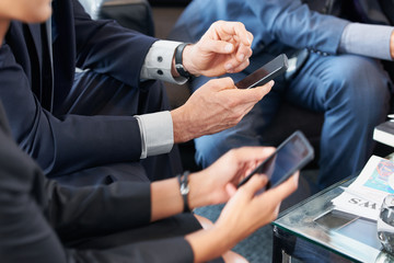 Business Professionals using devices to network and plan strategy