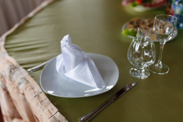 Plates with napkins and Cutlery for the wedding dinner. Decorated table ready to feast or Banquet.