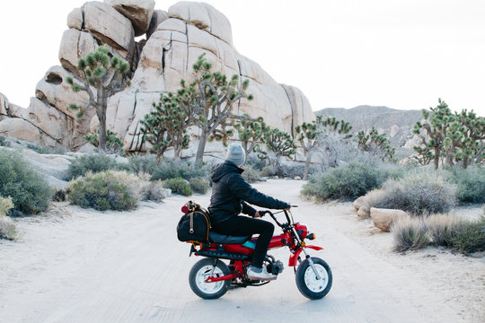 Young Male Riding Motor Bike In Desert