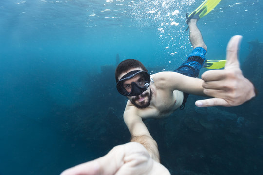 Man swimming underwater exploring the shipwreck