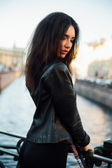 Portrait of a beautiful sexy brunette posing on a bridge on a river background.