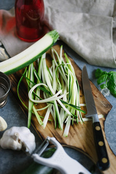 Strips of courgette on a chopping board, ready to be used in a recipe.