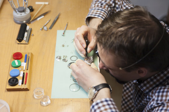Clockmaker working in workshop