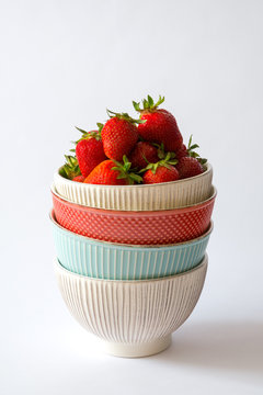 Freshly picked strawberries in pastel-colored stacked bowls