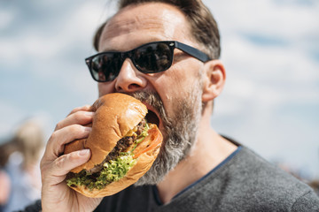 Food: Man eating a beef burger