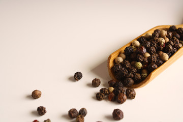 Pepper peas white black red in a wooden spoon