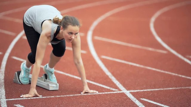 Female runner starting at the stadium