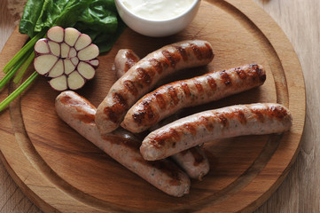 grilled bratwurst sausages with sauce, spinach and garlic