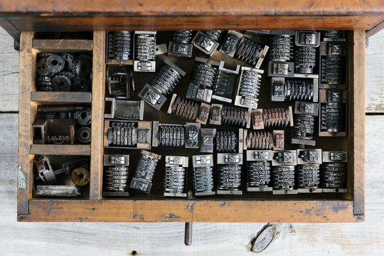 Old wood drawer filled with vintage metal numbering inserts for printer - from above