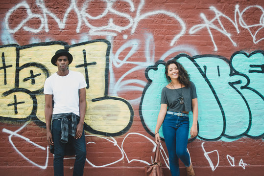 Couple standing in front of graffiti wall