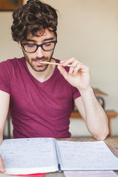 Handsome Young Man Studying for the Final Exams at College
