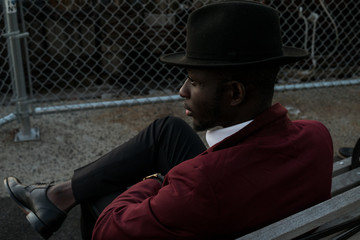 Young dapper man sitting on a bench