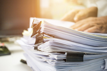 Businessman hands searching information in Stack of papers files on work in office, business report paper or piles of unfinished documents achieves with clips on offices Business concept - obrazy, fototapety, plakaty