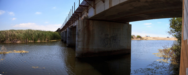 Water under the railroad track bridge leading down to the ocean