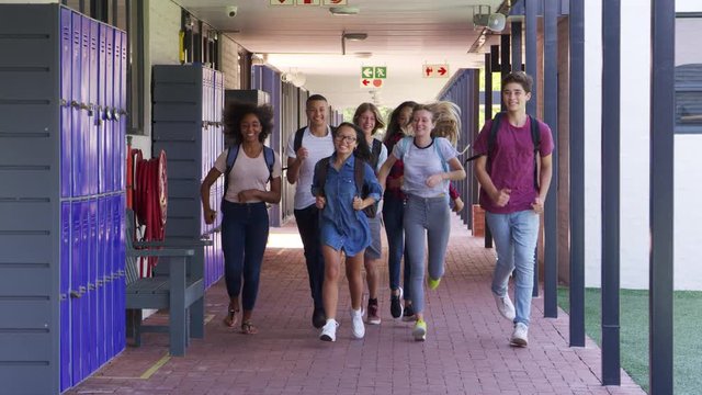 Teenage school kids running in high school hallway