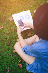 Young women use cell phones. In the Park in the morning sun