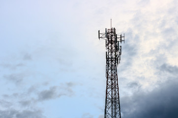 Communication tower with blue sky and cloud.