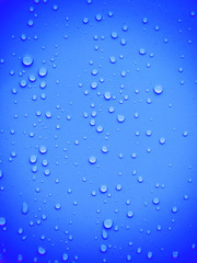 Naklejka na ściany i meble Water drops on blue background