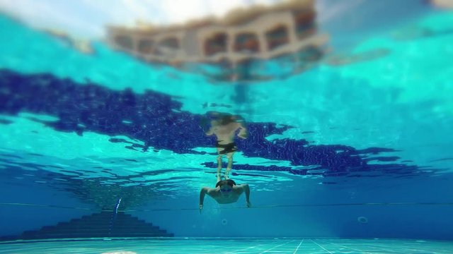 Active rest and healthy lifestyle, water sports in vacation holiday. Swimmer man floats, diver male dives in sunny pool with clear water at tourist resort. Underwater survey