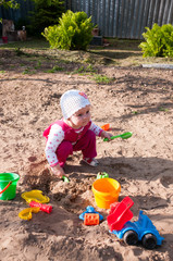 Child of year and half plays in sandbox