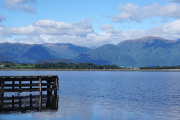 Wooden jetty into the lake with mountain range background