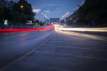 Traffic on city road through the bridge at twilight in Thailand. Long exposure shot photography by DSLR camera.