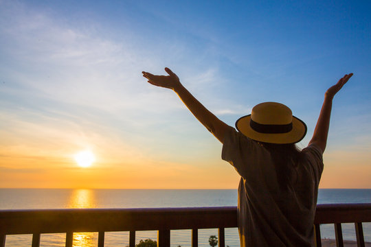 Traveller woman raise and straight the hand relaxing with sea view in sunset time with twilight sky