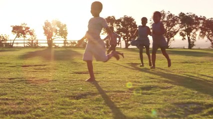 Elementary school kids playing with a football in a field