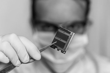 Scientist holding and examining damaged electrical component