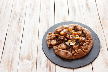 Galette with pears and cheese Brie. Called also Breton galette, galette des Rois, Galeta. French cuisine (food). On old wooden white background.
