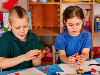 Small students with teacher painting in art school class. Child drawing by paints on table. Craft drawing education develops creative abilities of children. Zoo from plasticine.