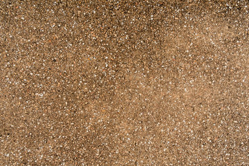 Brown small stone wall texture background, ground stone washed floor, made of small sand stone mixed