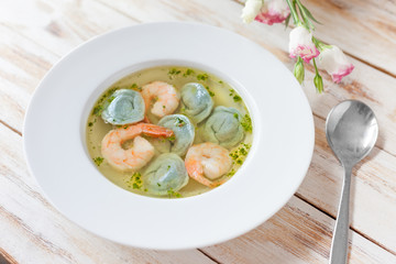 Soup dumplings and shrimp served with leek. On old wooden white background.
